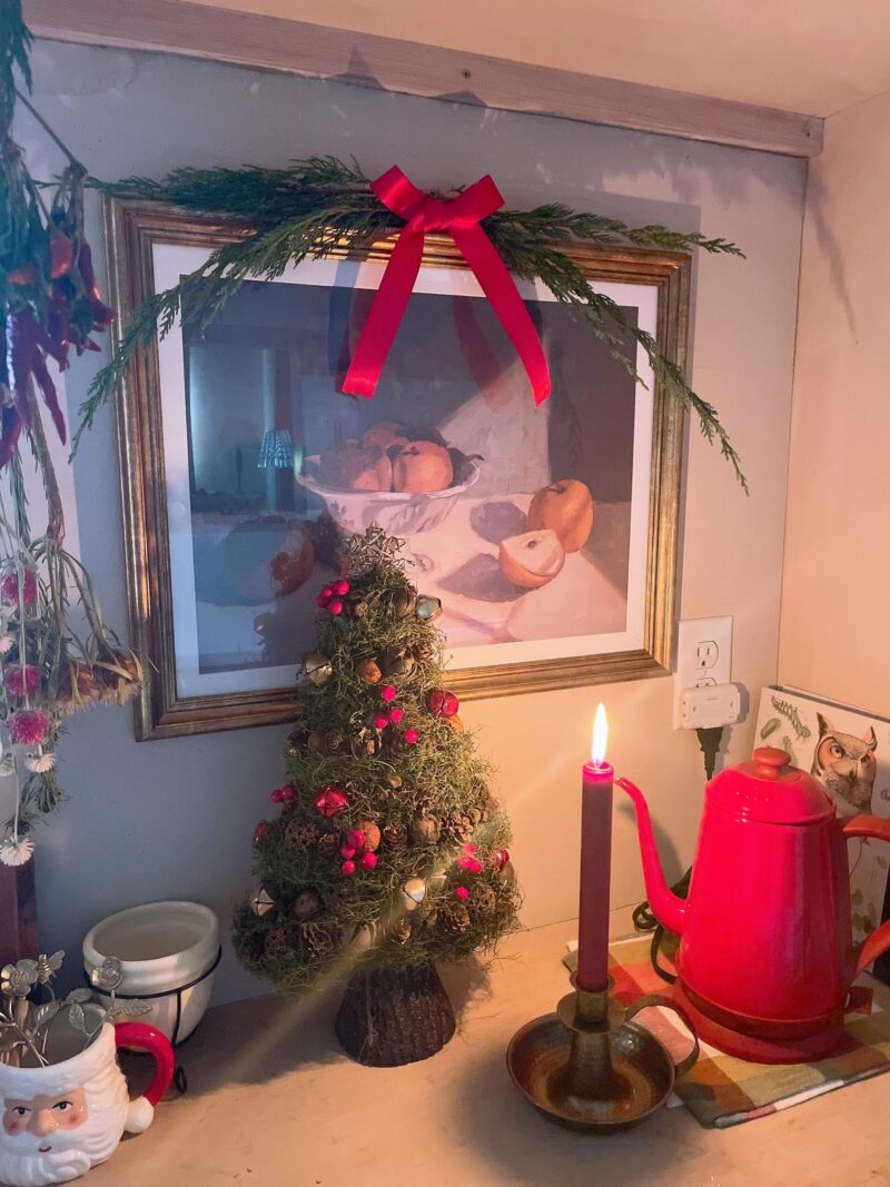 キッチン背面カウンターの絵を常緑樹のスワッグと赤いリボンで装飾。